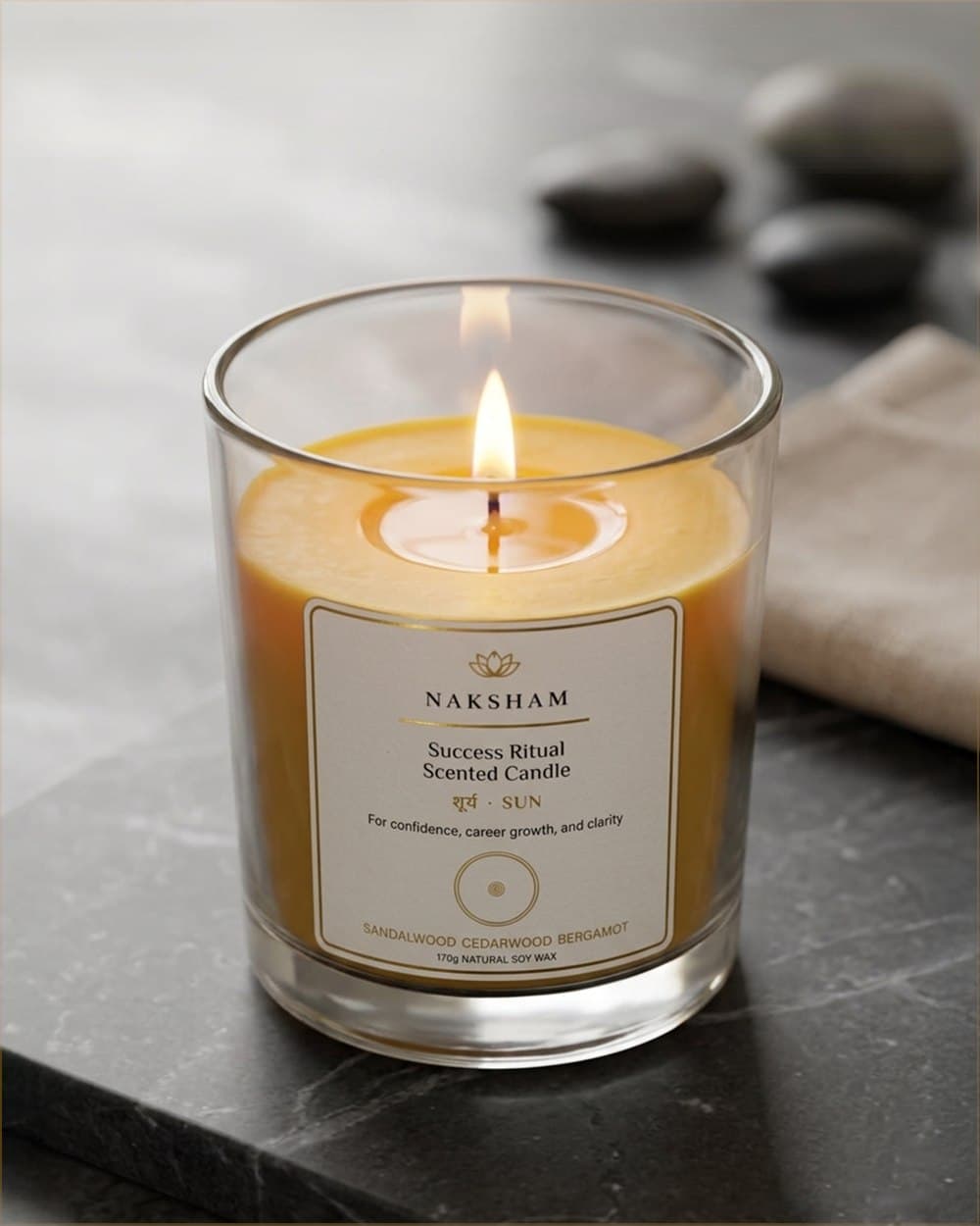 Naksham Navagraha planetary candle in clear glass, natural soy wax, set on a warm cream surface.
